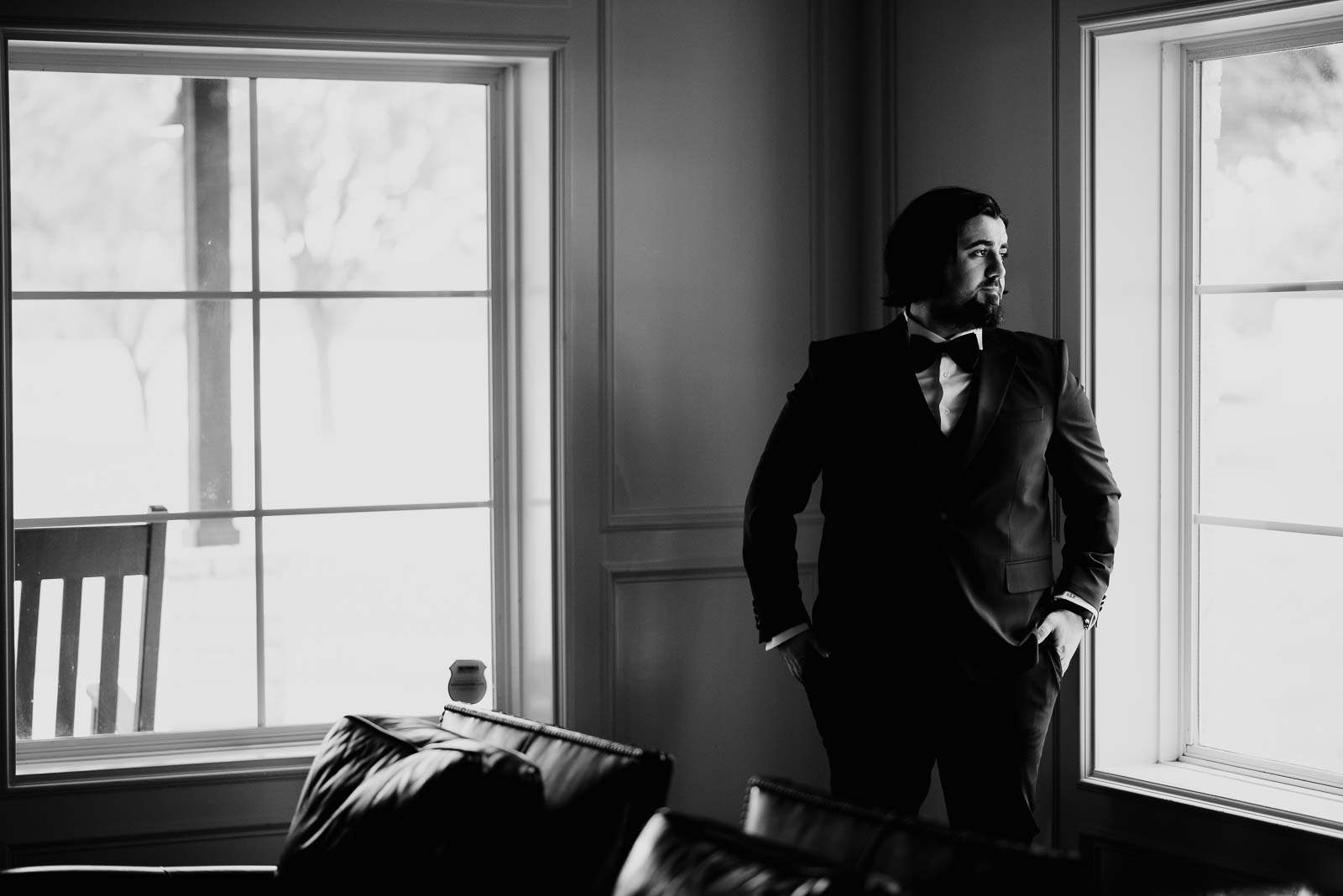 Groom waits in a house looking out of the window