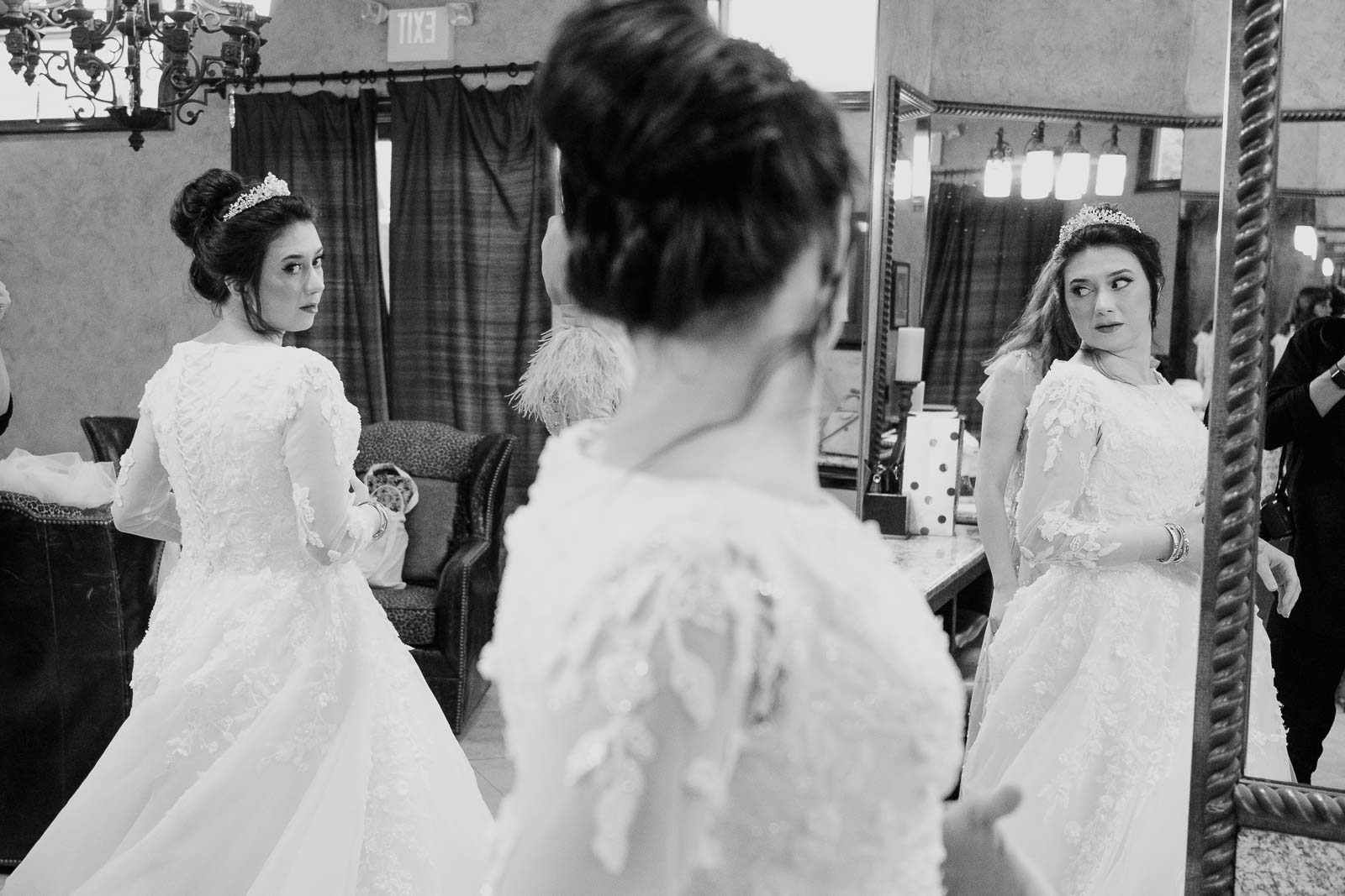 Busra, the bride  looks over his shoulder into the mirror and multiple reflections