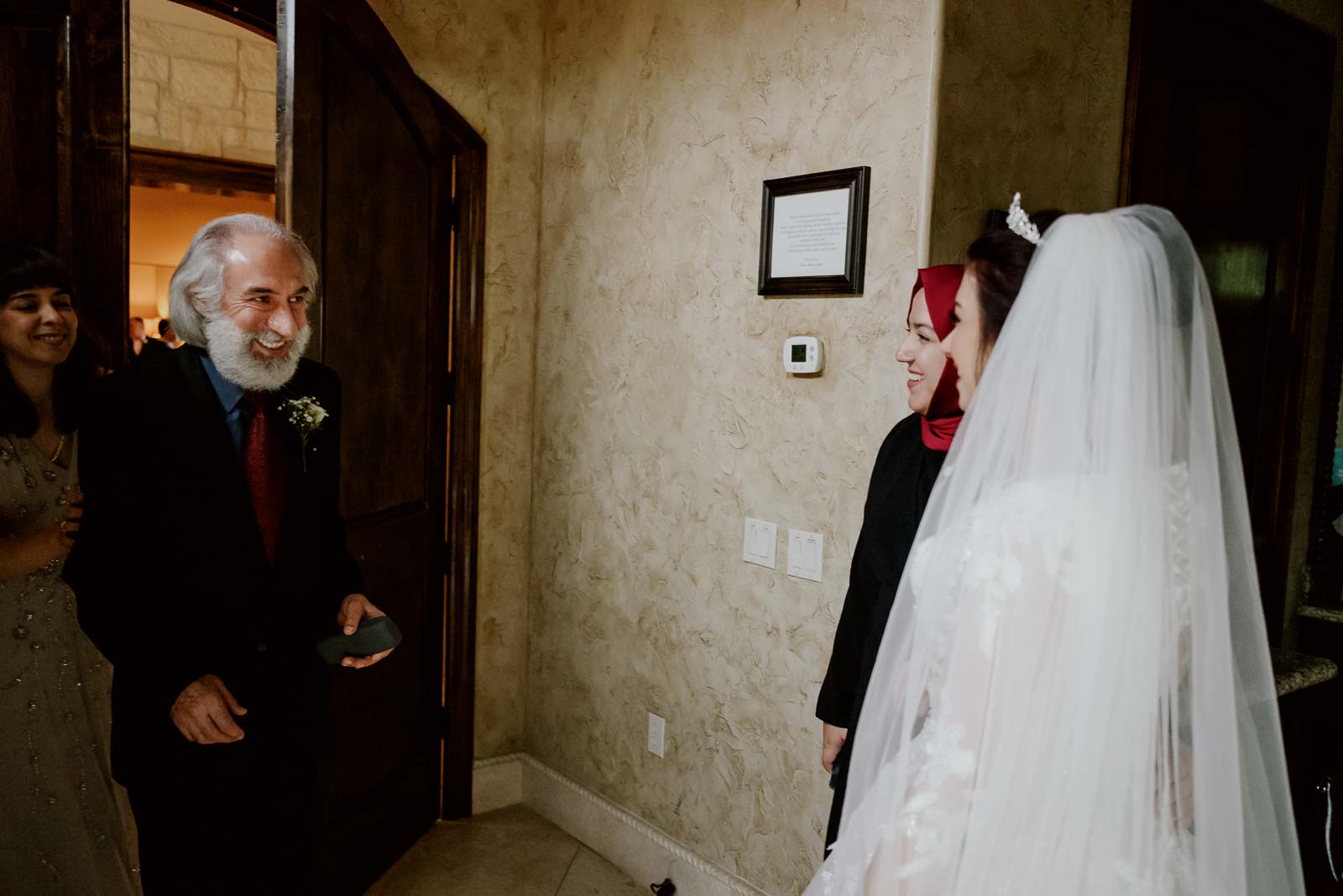 The father of the bride is delighted the beaming smile as he sees his daughter for the first time dress as a bride a Turkish wedding