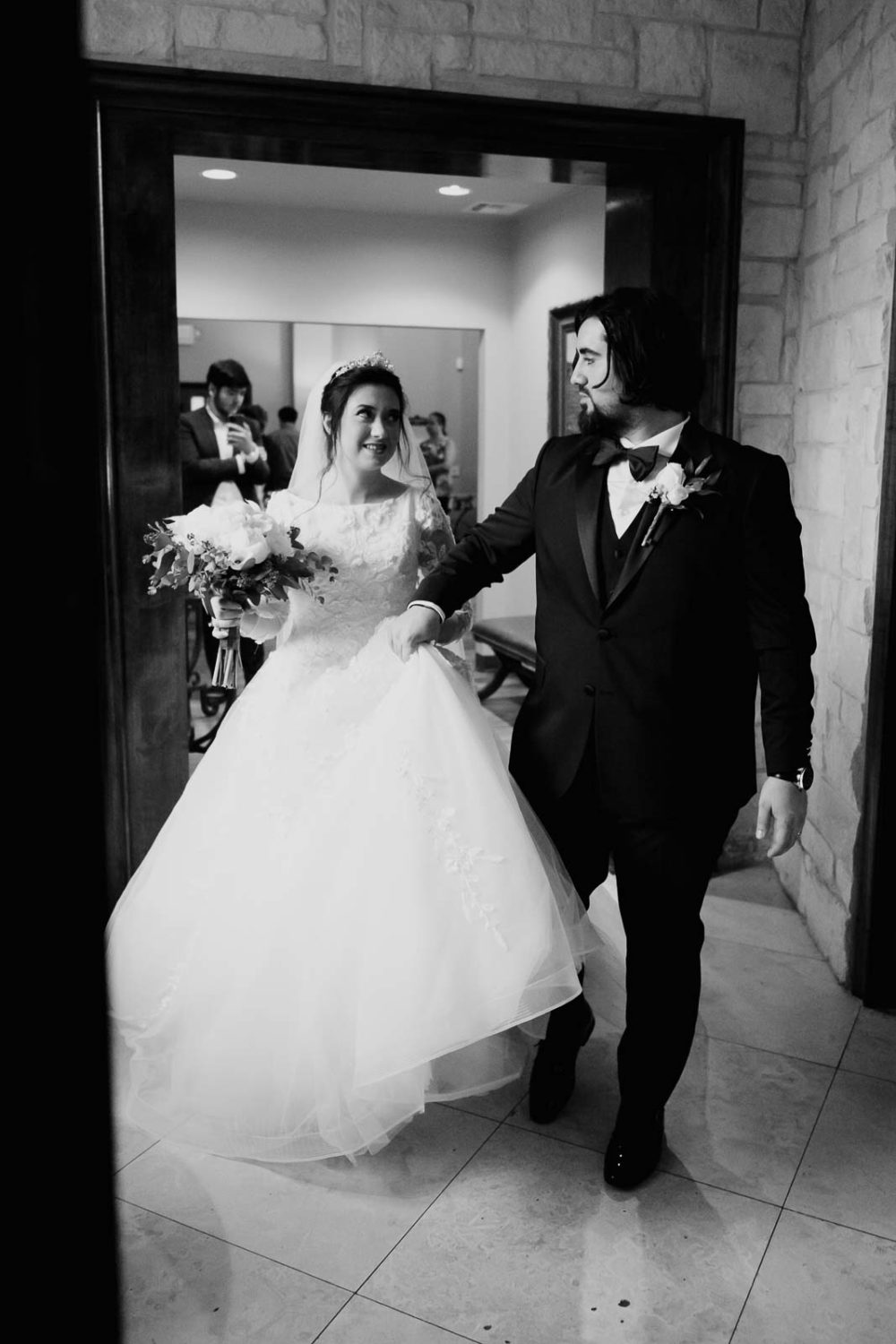 bride looks towards her husband as a newlywed look for a happy entering the bottle room