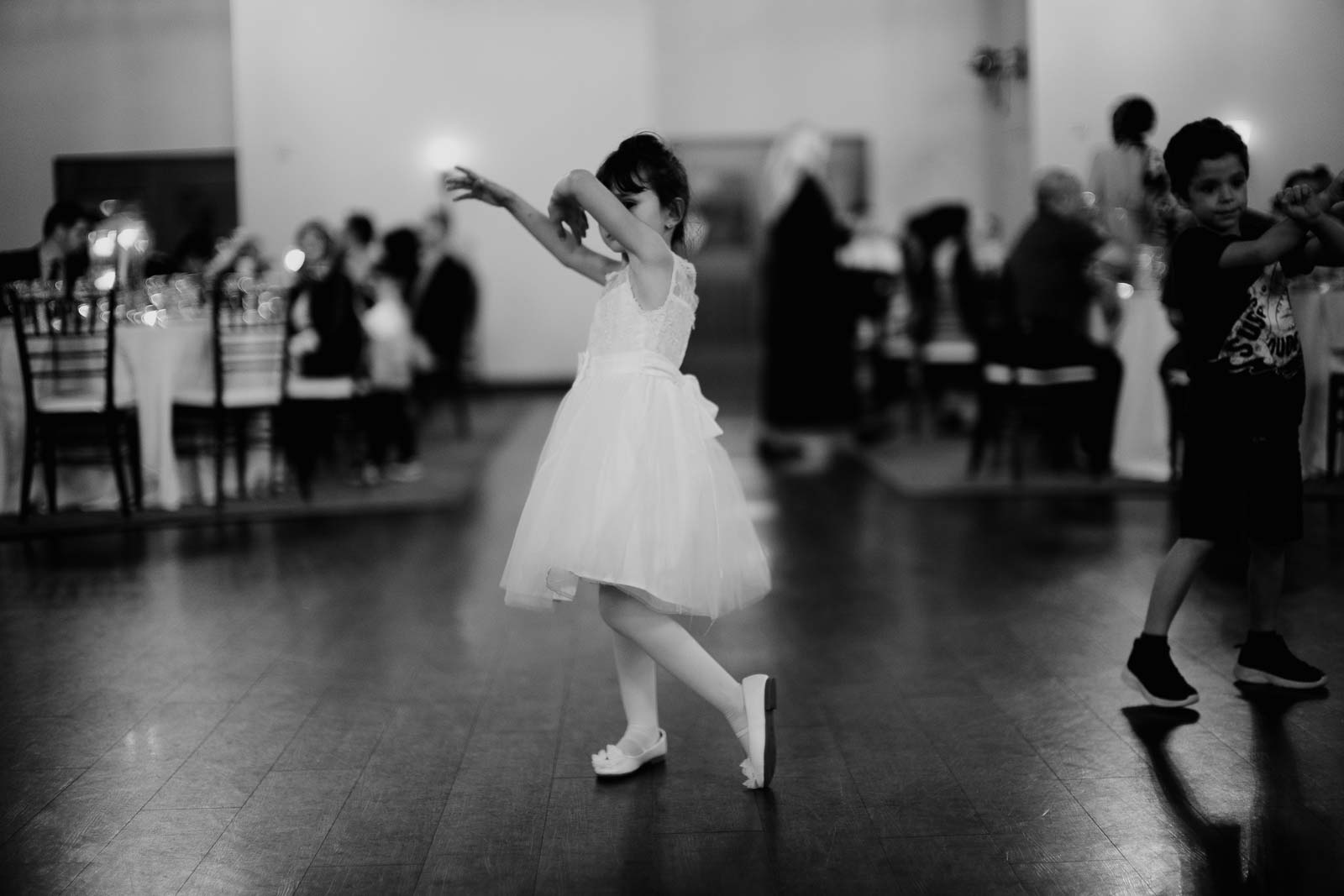 A flowrgirl girl dances at the reception
