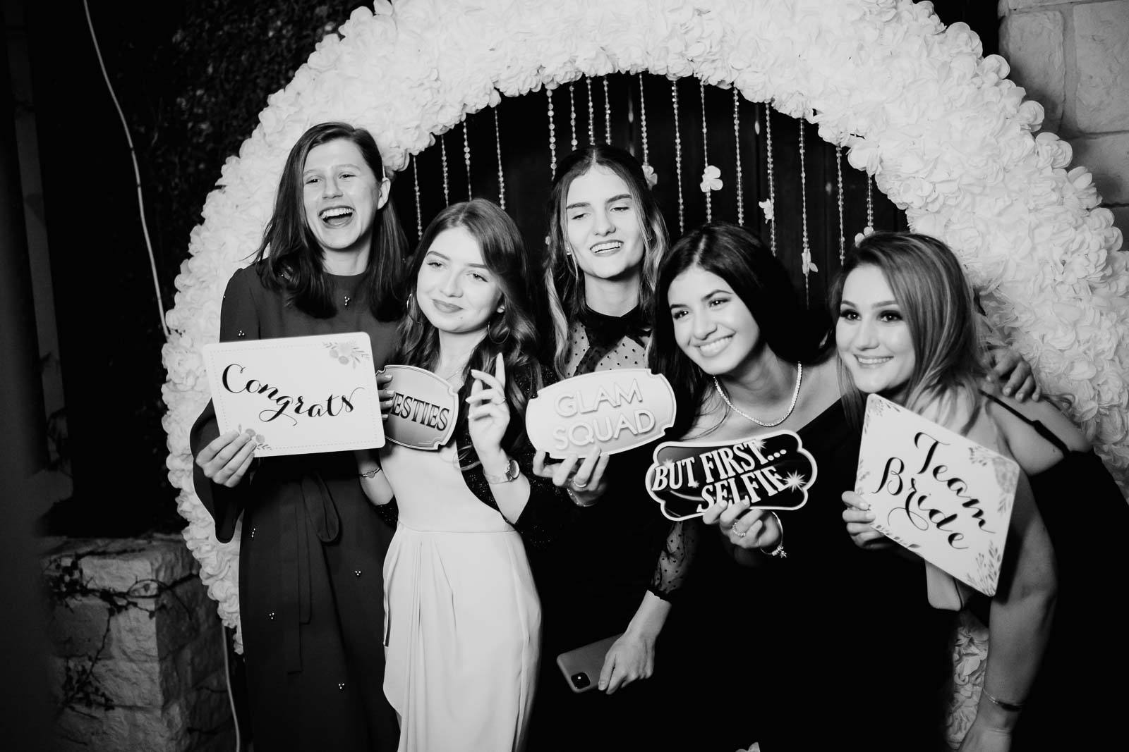 Friends pose in front of a corner studio at a wedding