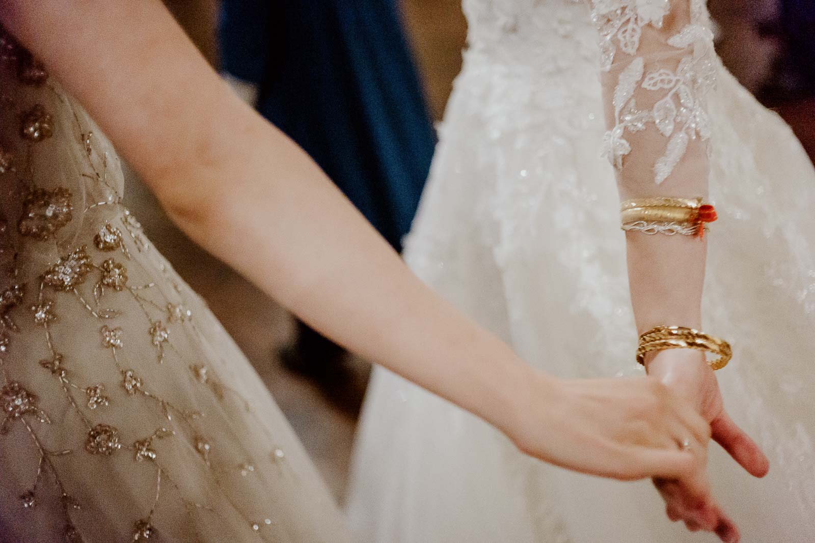 The bride holds hands with her sister at wedding reception