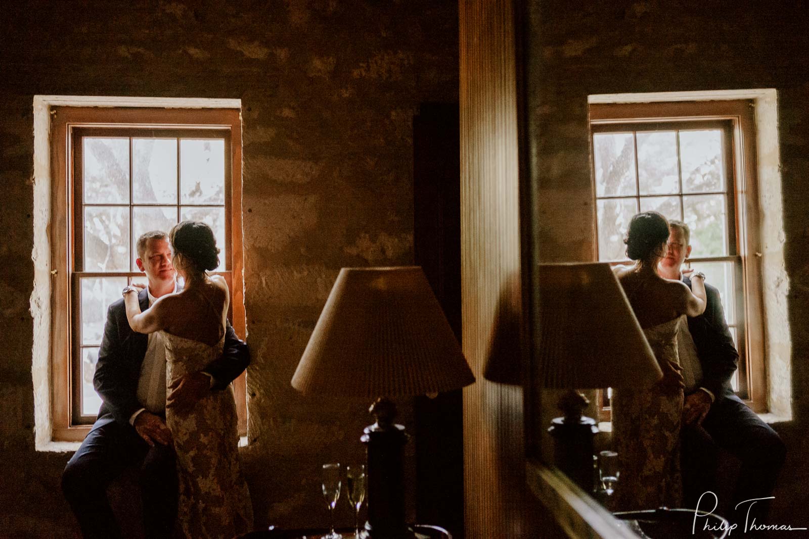 A couple pose at window captured in a reflection mirror atClub Giraud Wedding Reception San Antonio weddings Philip Thomas Photography