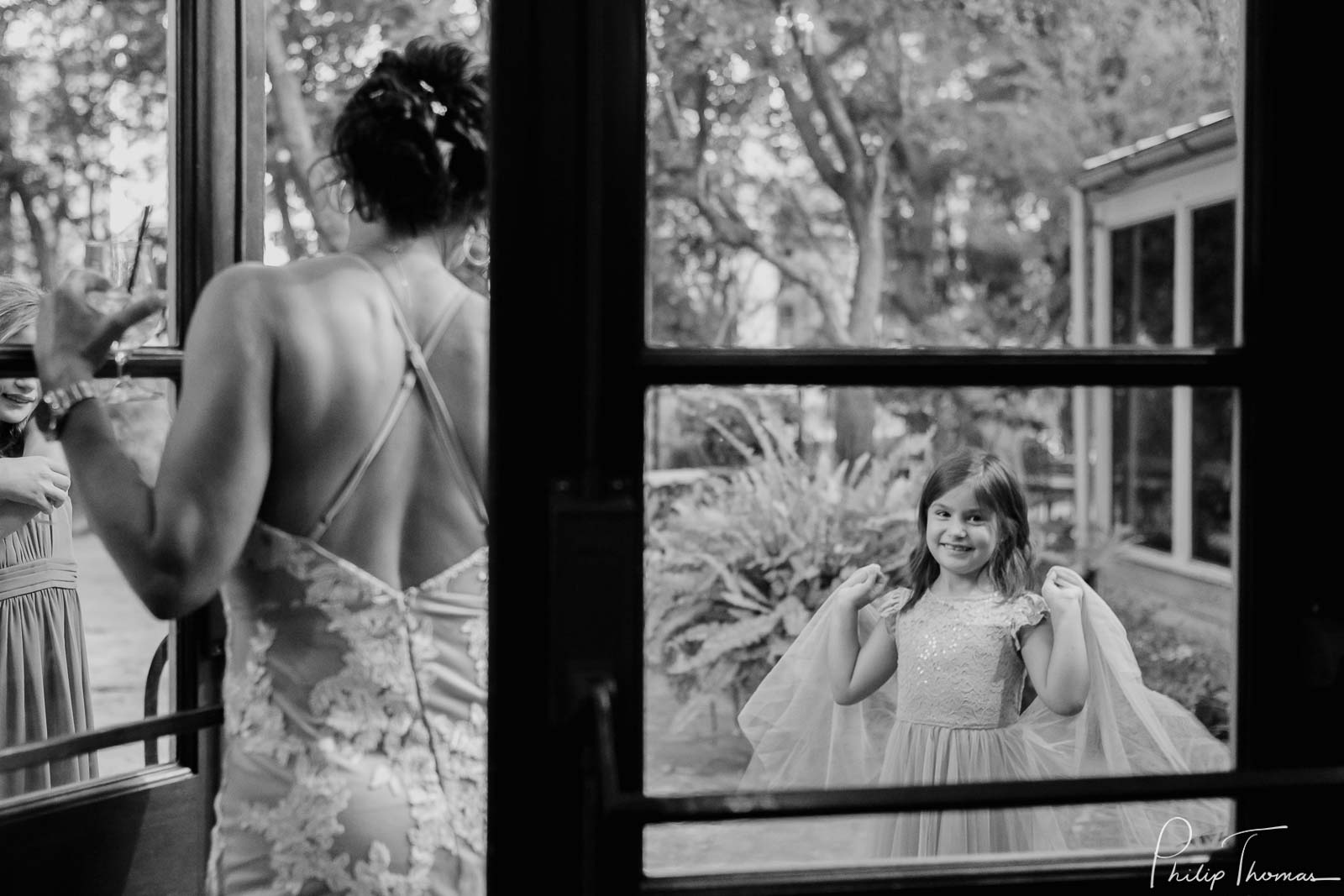 A flowergirl shows of her dress to the bride  Club Giraud Wedding Reception San Antonio weddings Philip Thomas Photography