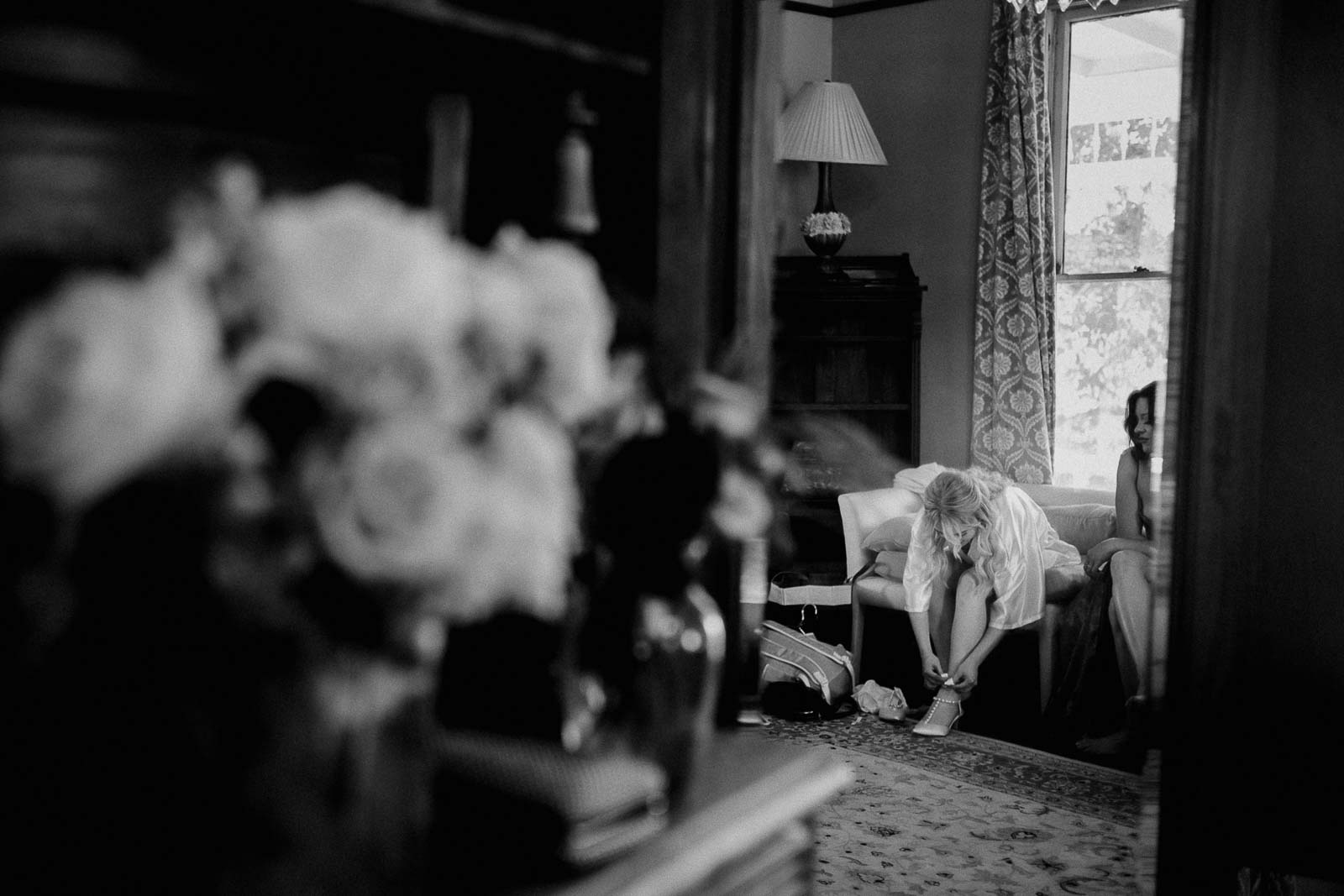 The bride ties her shoes on her wedding day at Barr Mansion