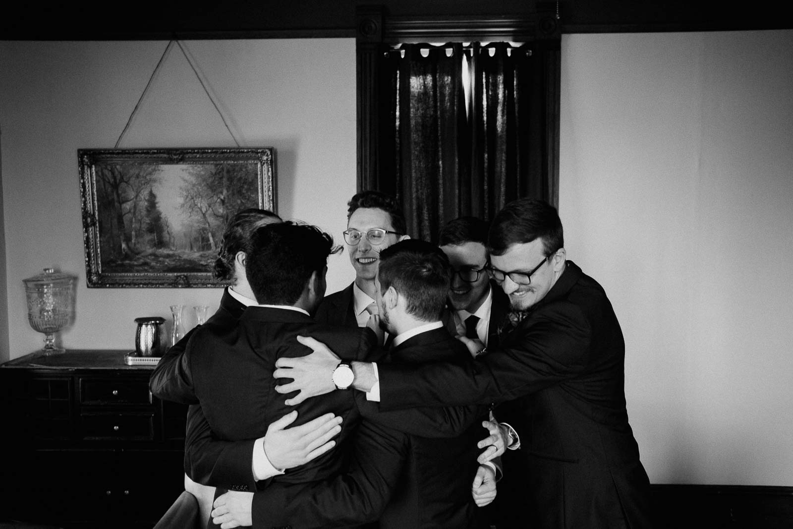 All the groomsmen hug in one huddle with the groom