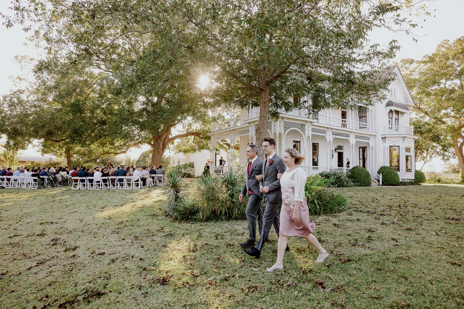 The groom is walked down the aisle, or in this picture around the house first with his parents