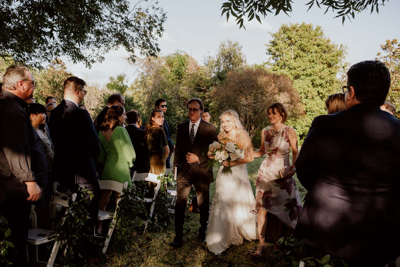 Sun shines on the bride as she is walked down the aisle with her father