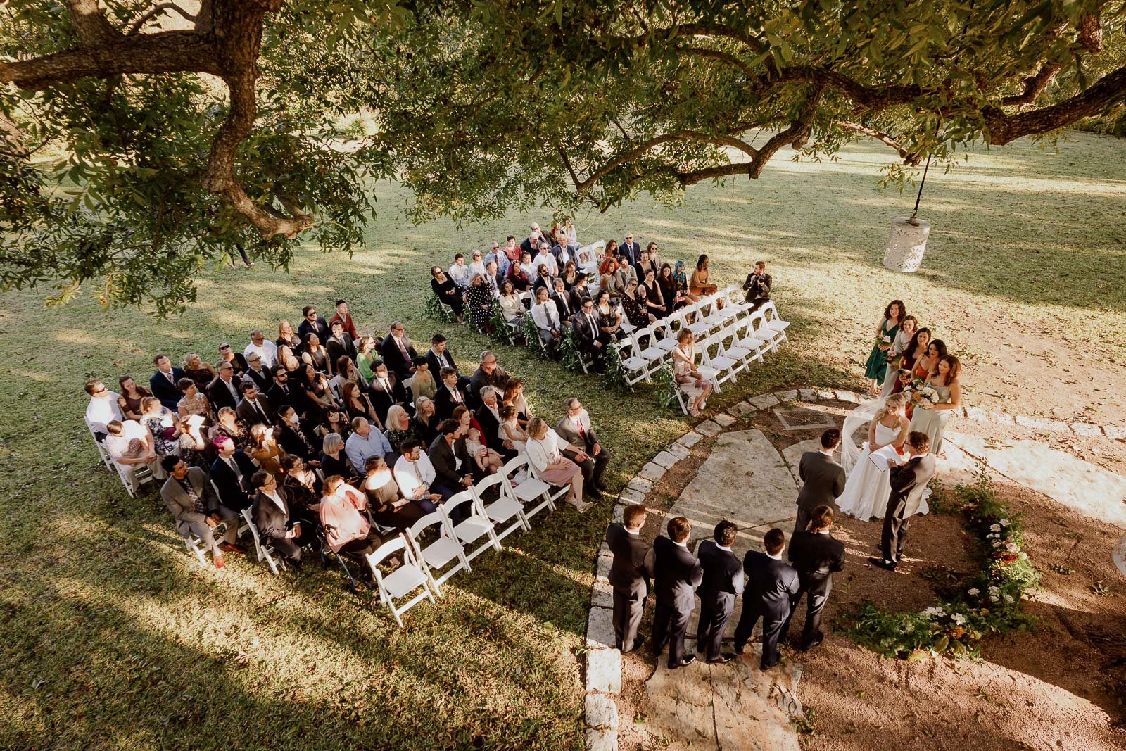 An overhead view of a wedding ceremony showing the bridal party and guests seated at Barr Mansion in Austin, Texas