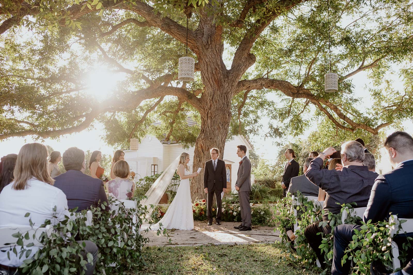 The bride reads her vows to her groom at Barr Mansion with beautiful light at sunset