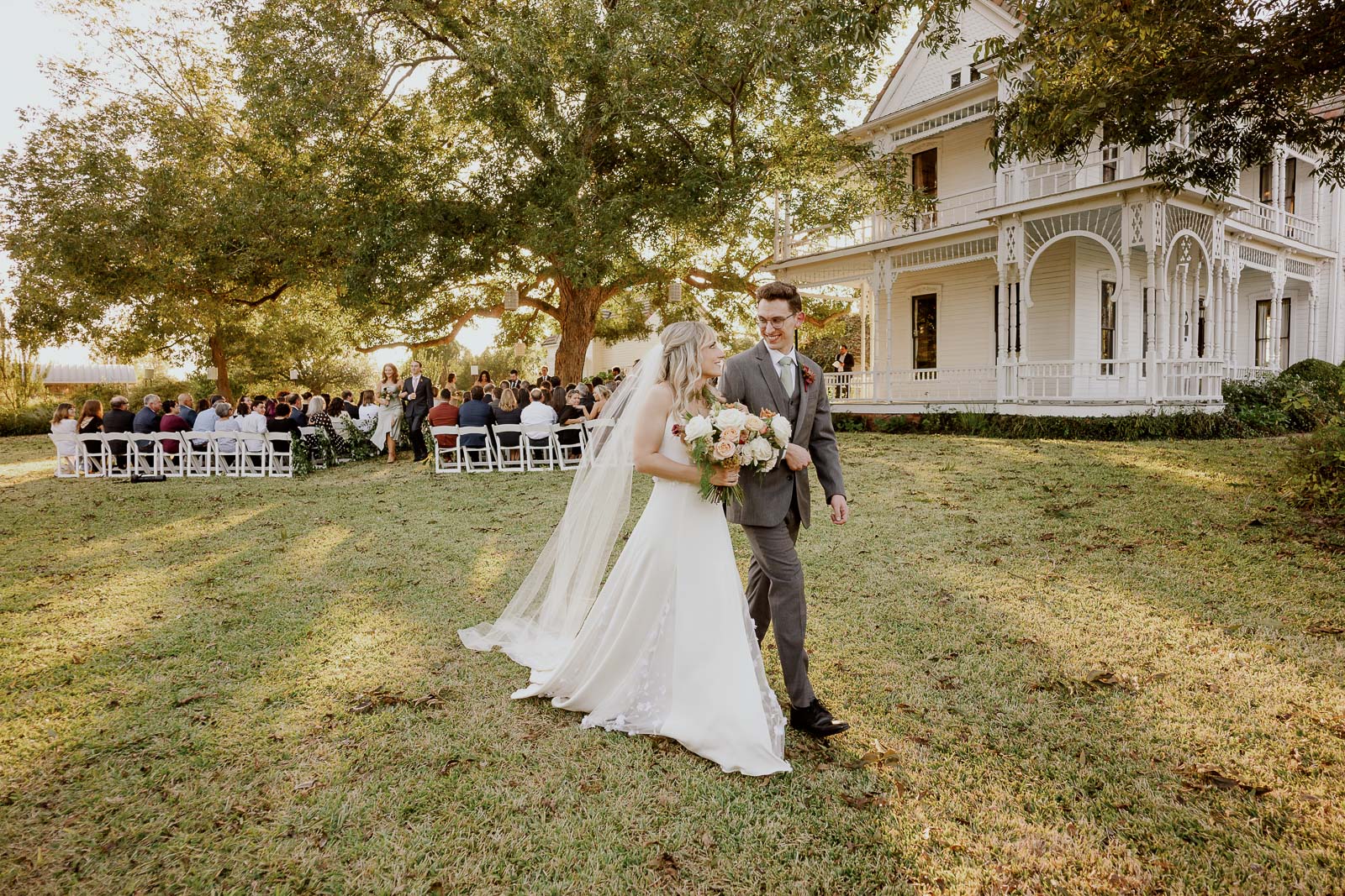 The newly minted couple look at each other as they walk away from the ceremony