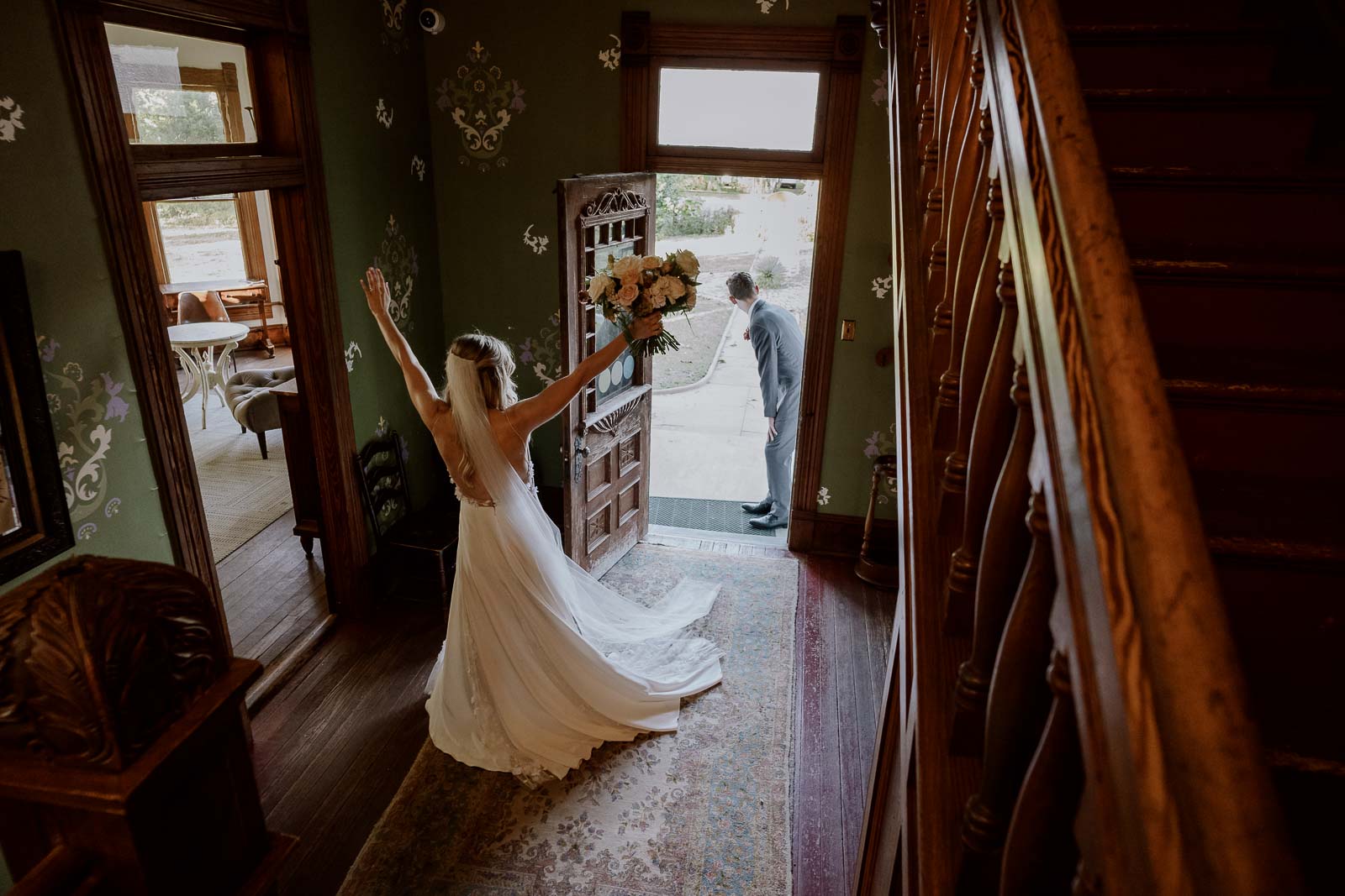 The second of three images as the brides turns toward her husband with her hands raised in jubilation