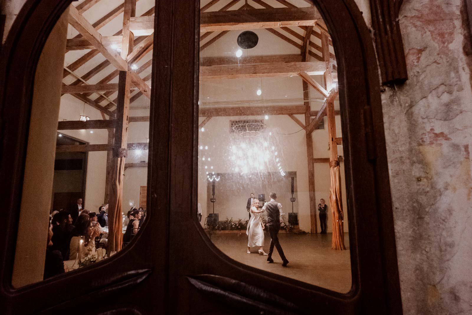 The couples first dance viewed from outsode the ballroom looking in