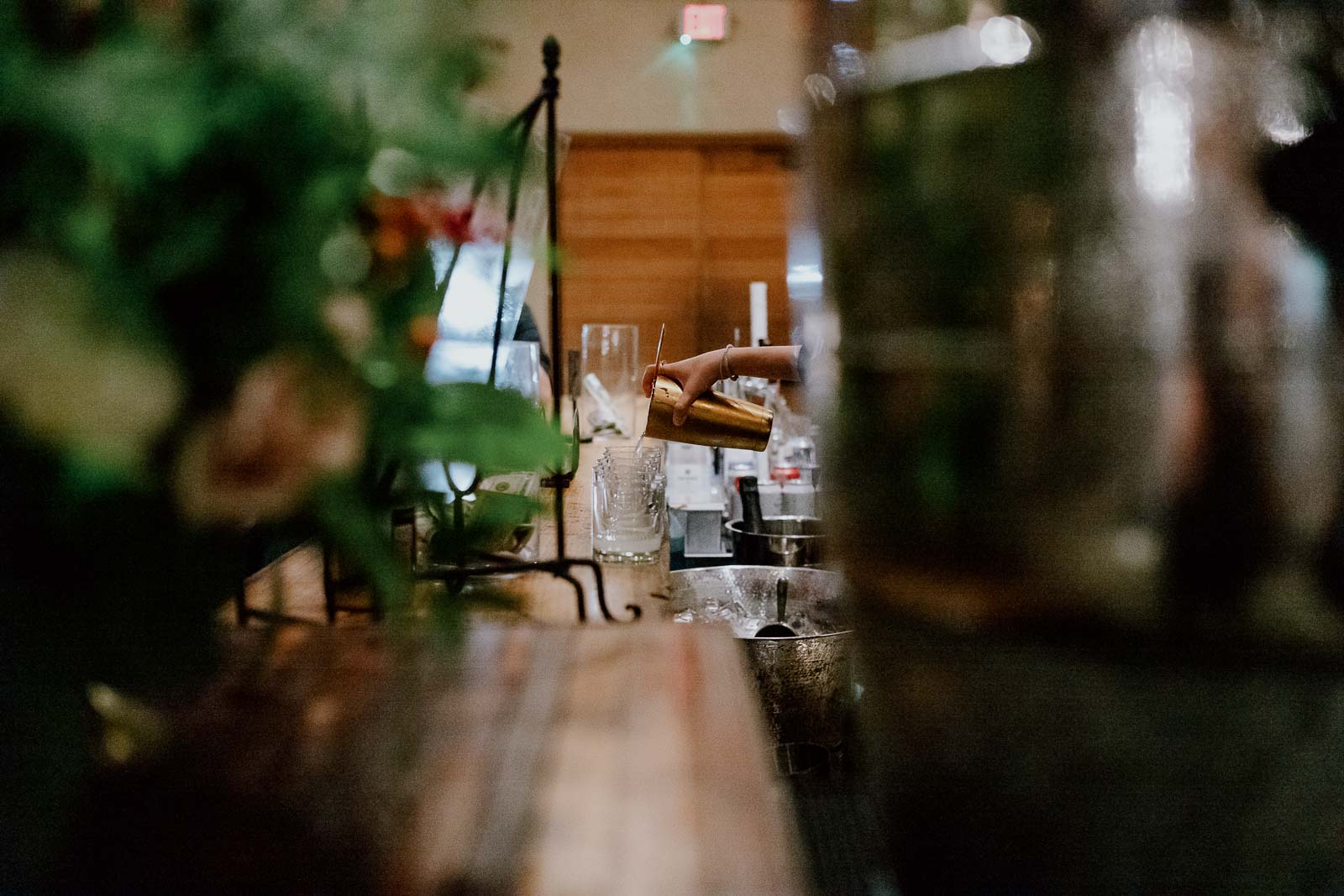 Bar staff pours a mixed drink into a glass