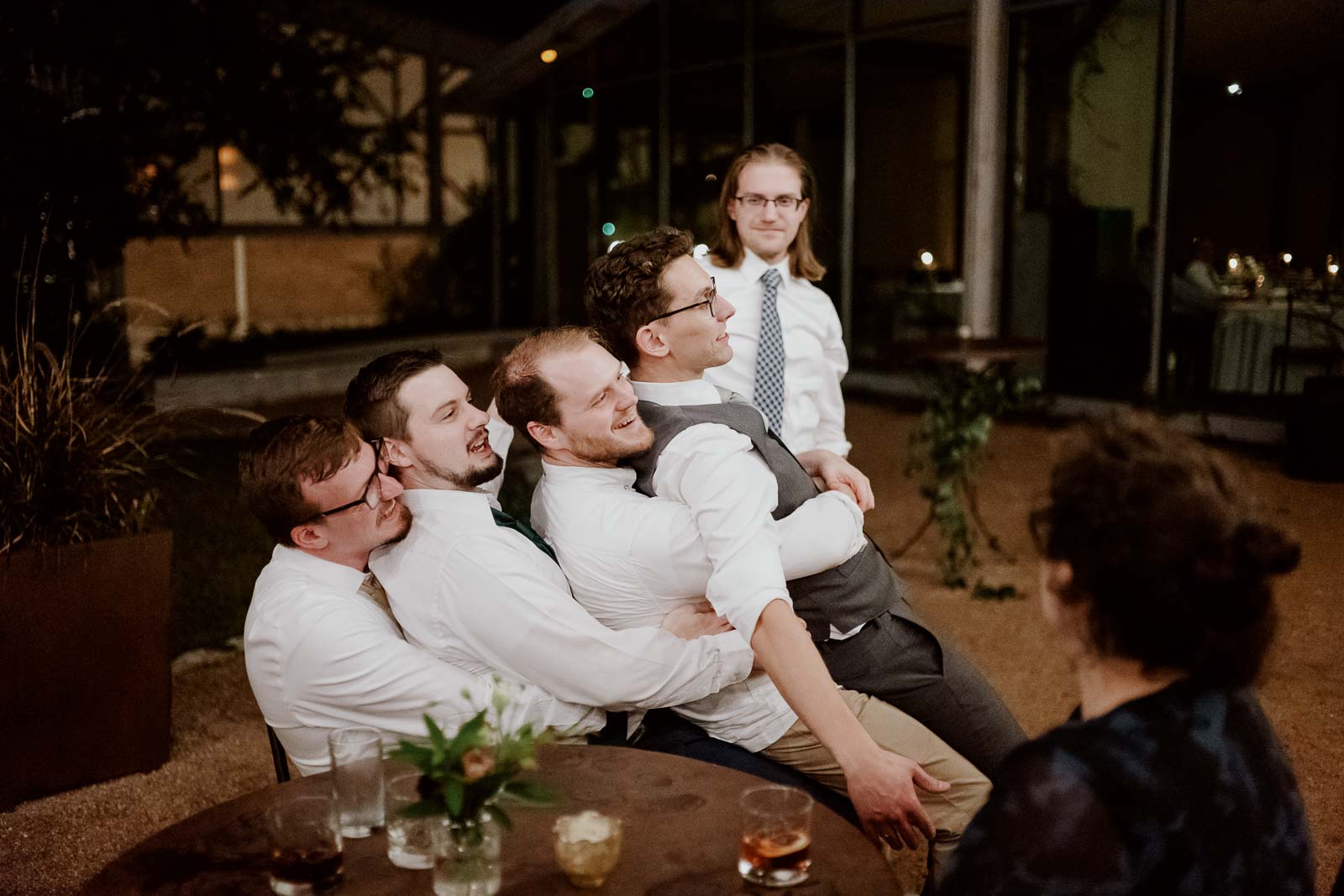 Friends of the groom gather and sit on top of each other in a comical moment