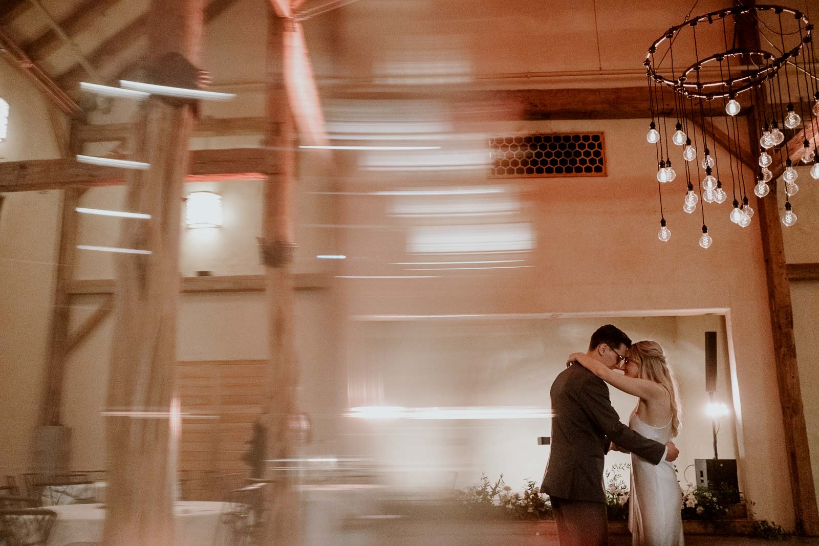 Last dance for couple with brides arms wrapped around grooms shoulders.