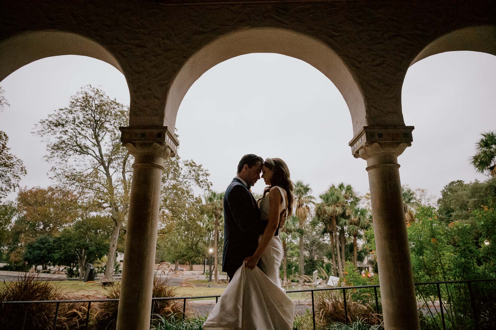 A posed portrait of the wedded couple at the McNay Art Museum arches