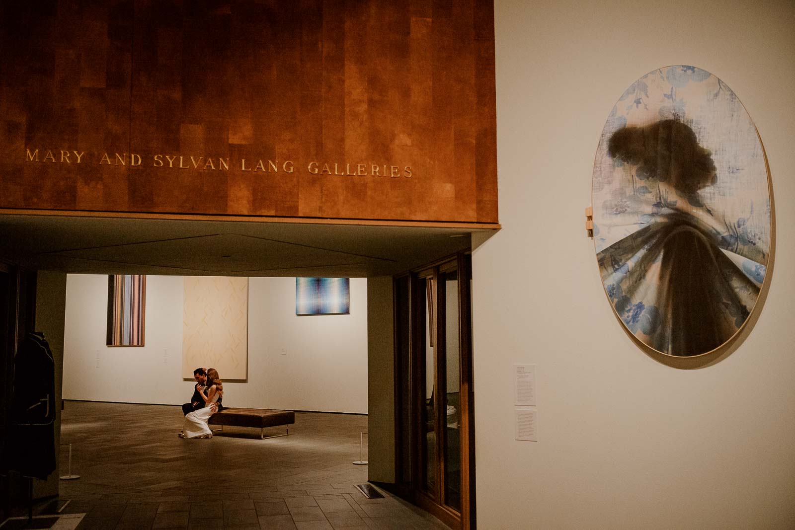 A couple enjoy the art Mary and Sylvan Lang gallery together at the McNay seated down