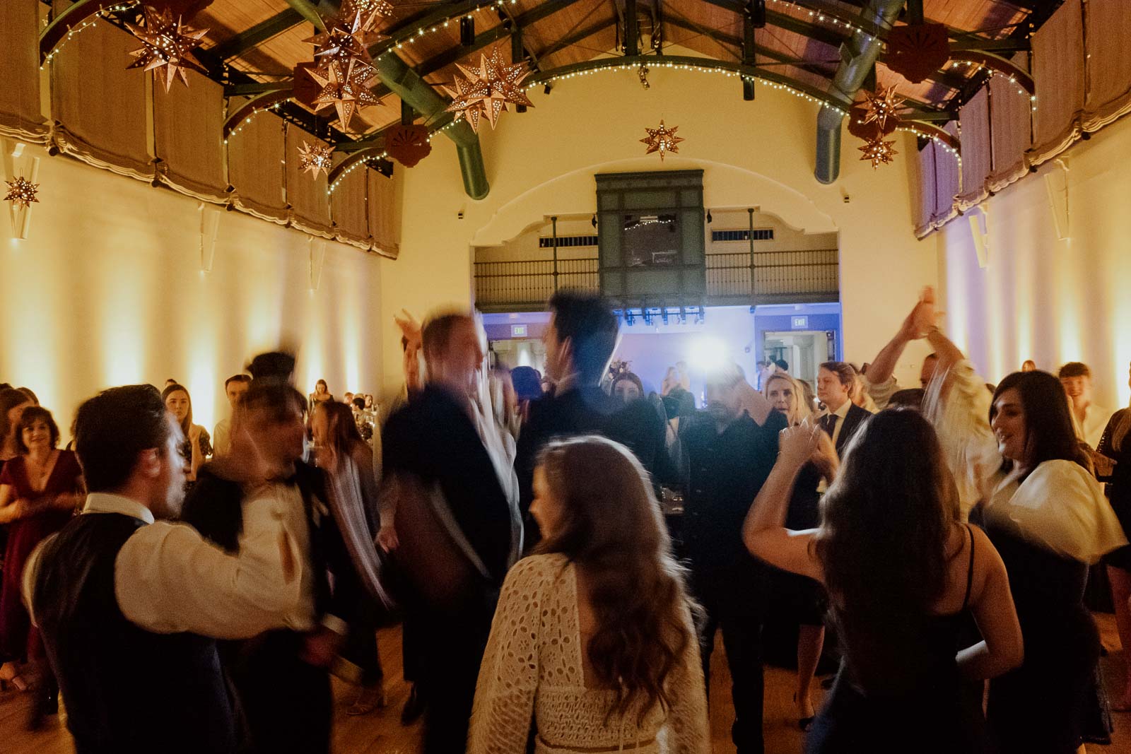 Wedding guests jump up and down at a McNay reception captured with a slow shutter speed