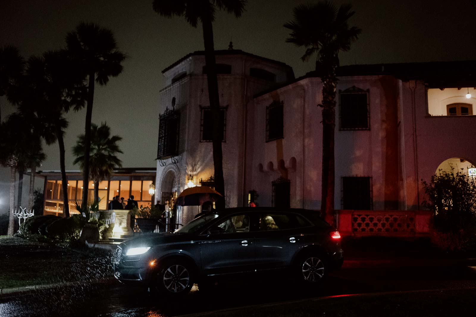 The couple depart as rain falls captured on the grounds of the McNay