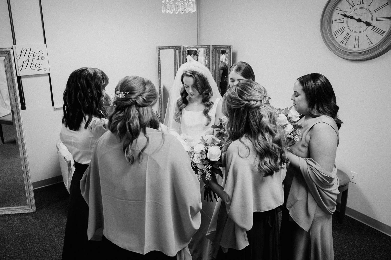 Pre wedding ceremony shows bridesmaids and bride praying