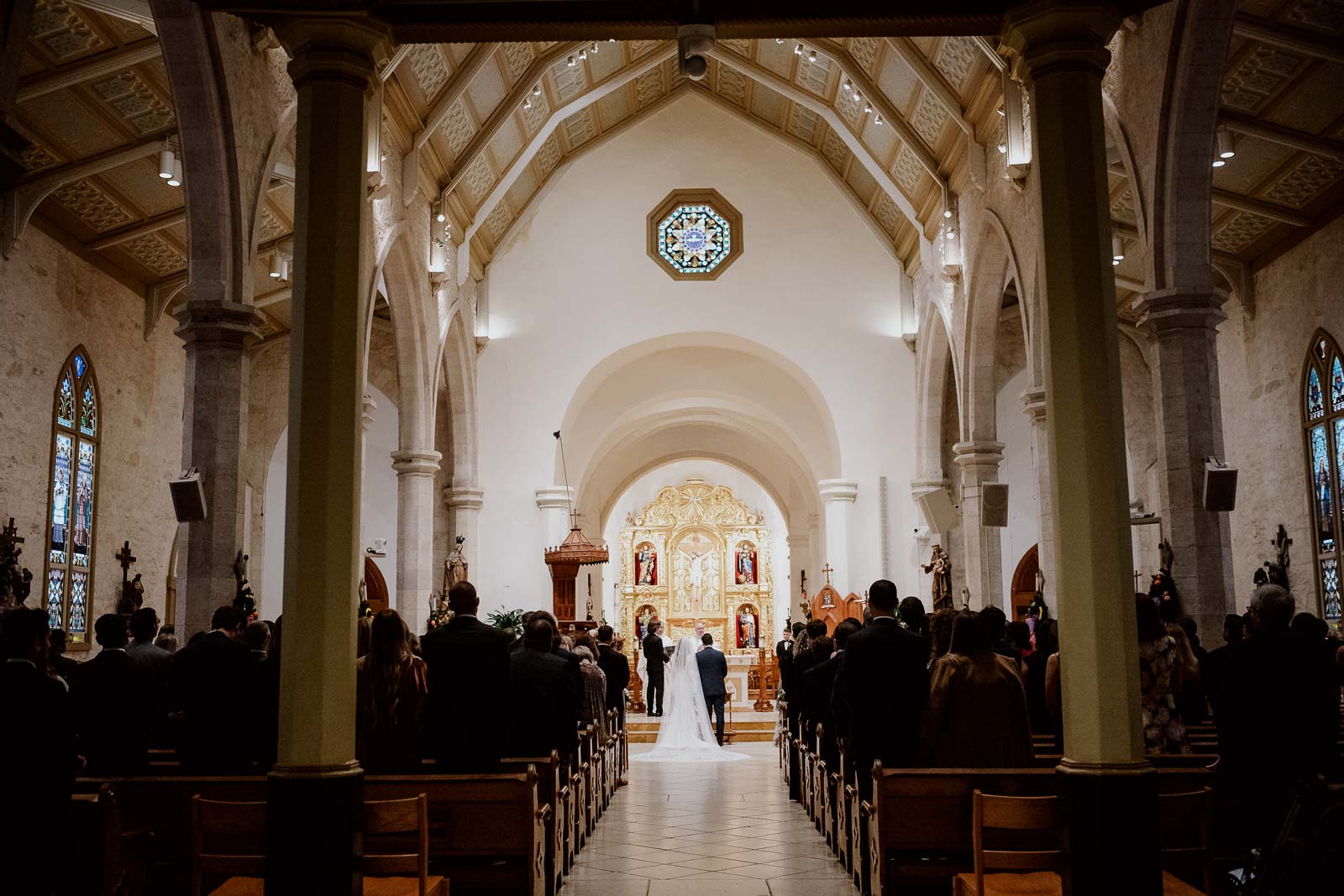 A wide angle photo from the back of San Fernando Cathedral during a catholic wedding ceremony