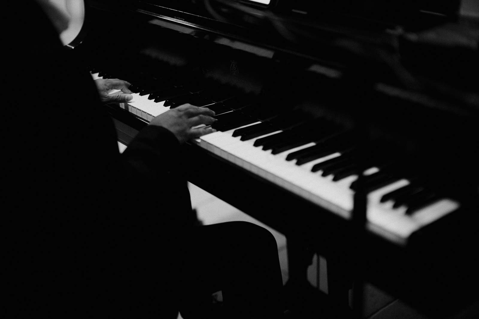 A pianist striking keys during a wedding ceremony