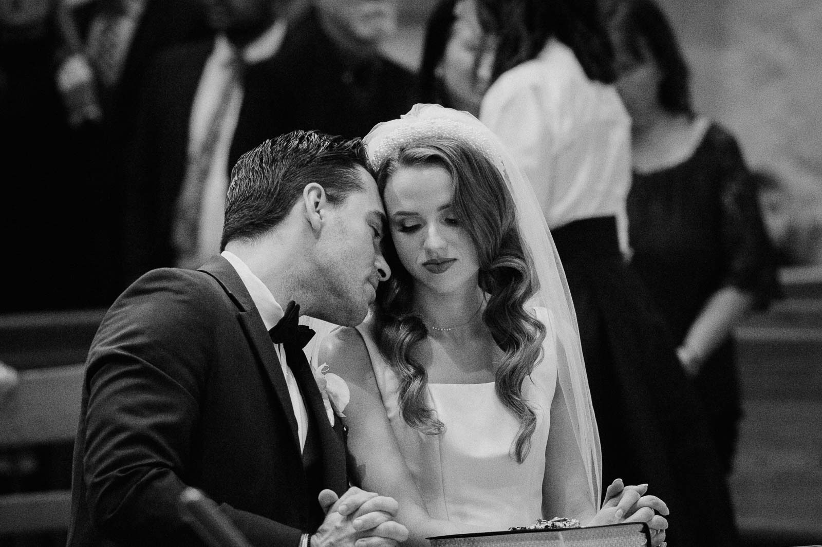 A touching moment shows the groom leaning over toward the bride after their vows