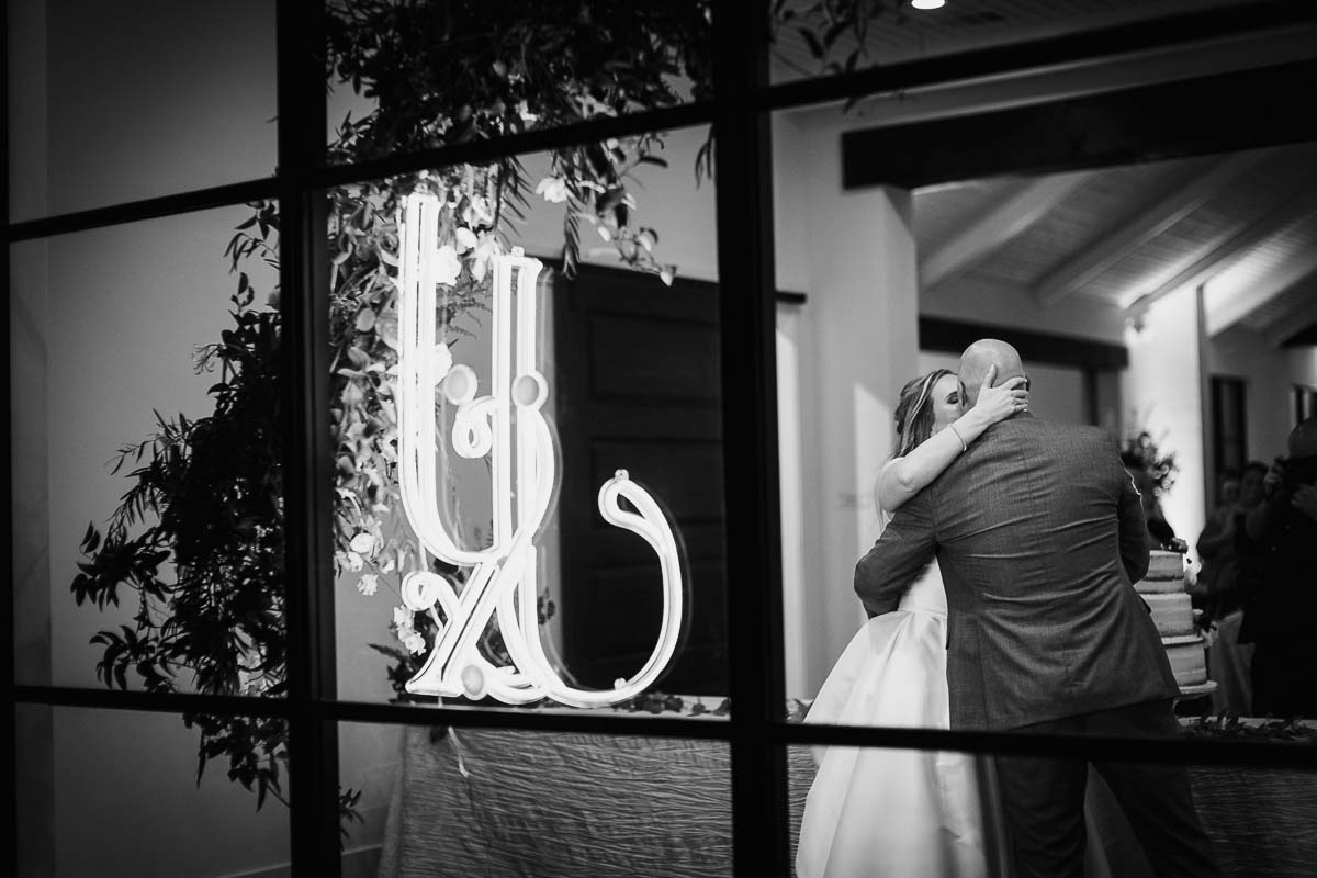 Wedded couple kiss after cutting the cake at Hayes Hollow at Hidden Falls in Spring Branch