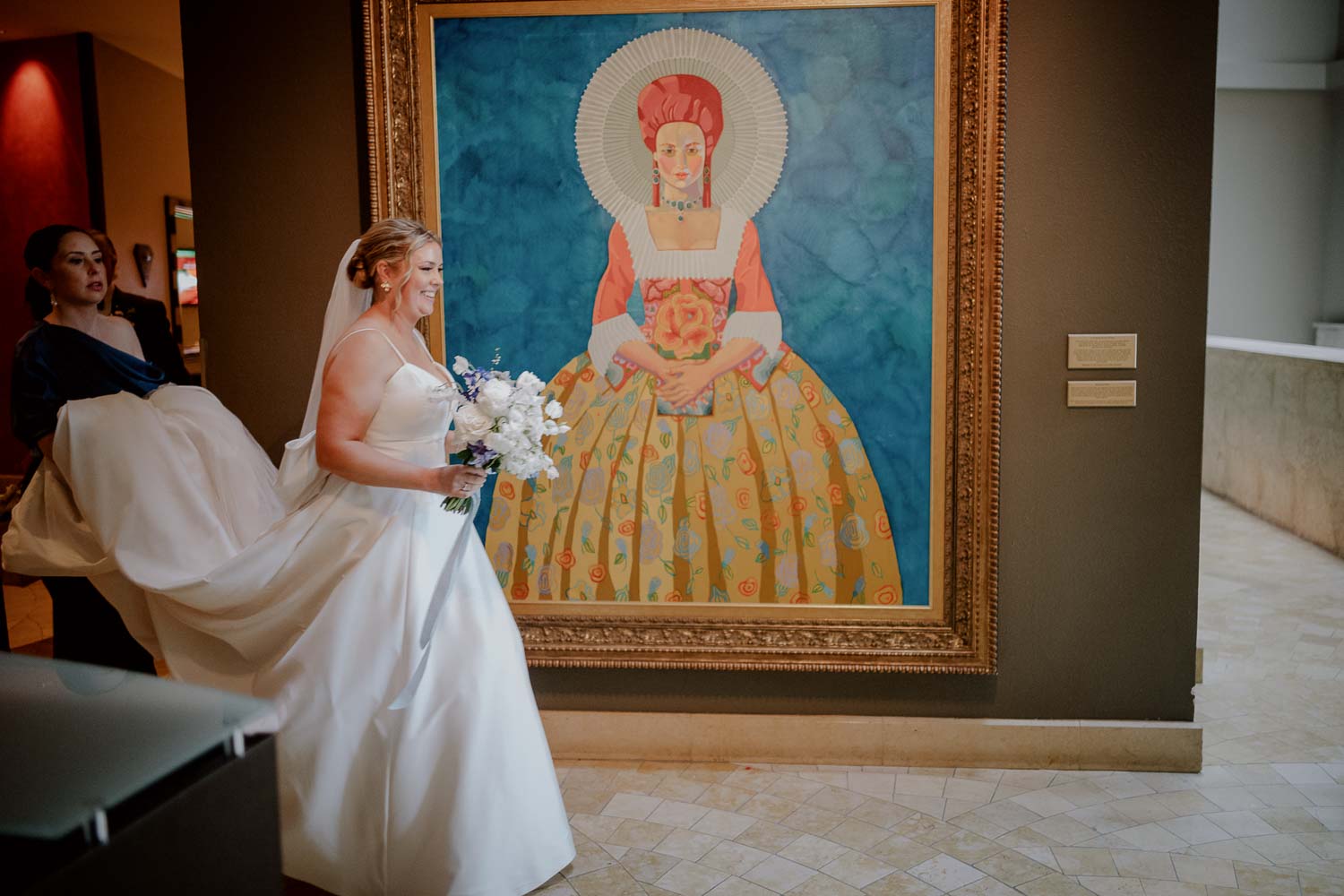 A bride passes a beautiful painting at The Contessa Hotel on the Riverwalk in San Antonio Texas