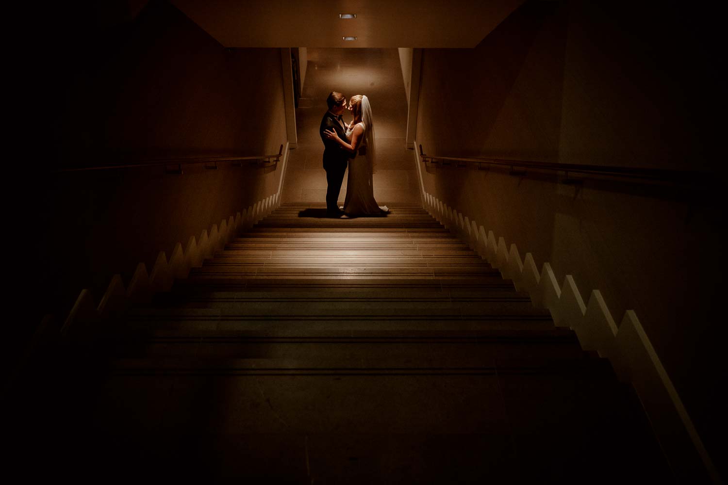 Lauren and Augustin pose under the stair at C Baldwin hotel on their wedding day