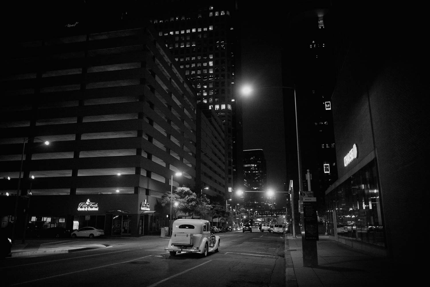 The wedded couple depart in an antique car driving off in downtown Houston from the C.Baldwin Hotel