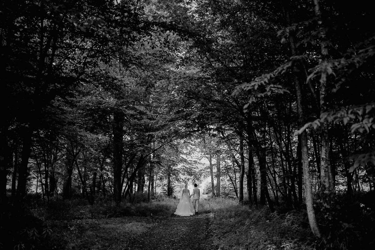 076 The just wedded couple walk into the distance after tying the knot at The DeBruce Iin Livingston Manor wedding ceremony and reception in New York Leica photographer Philip Thomas Photography