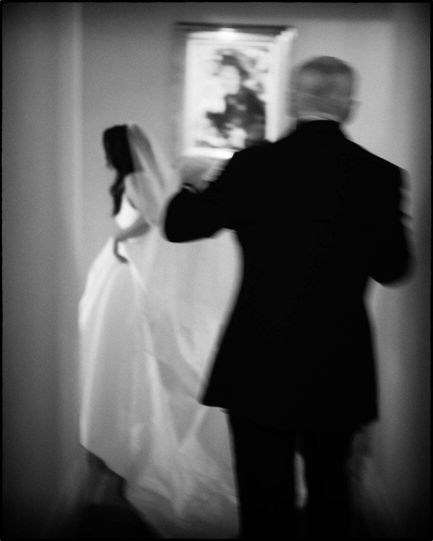 Father of the bride holds his daughter bridal gown as she walks through her parents home - Kendalia Hill Country Wedding Ceremony + Reception Philip Thomas Photography
