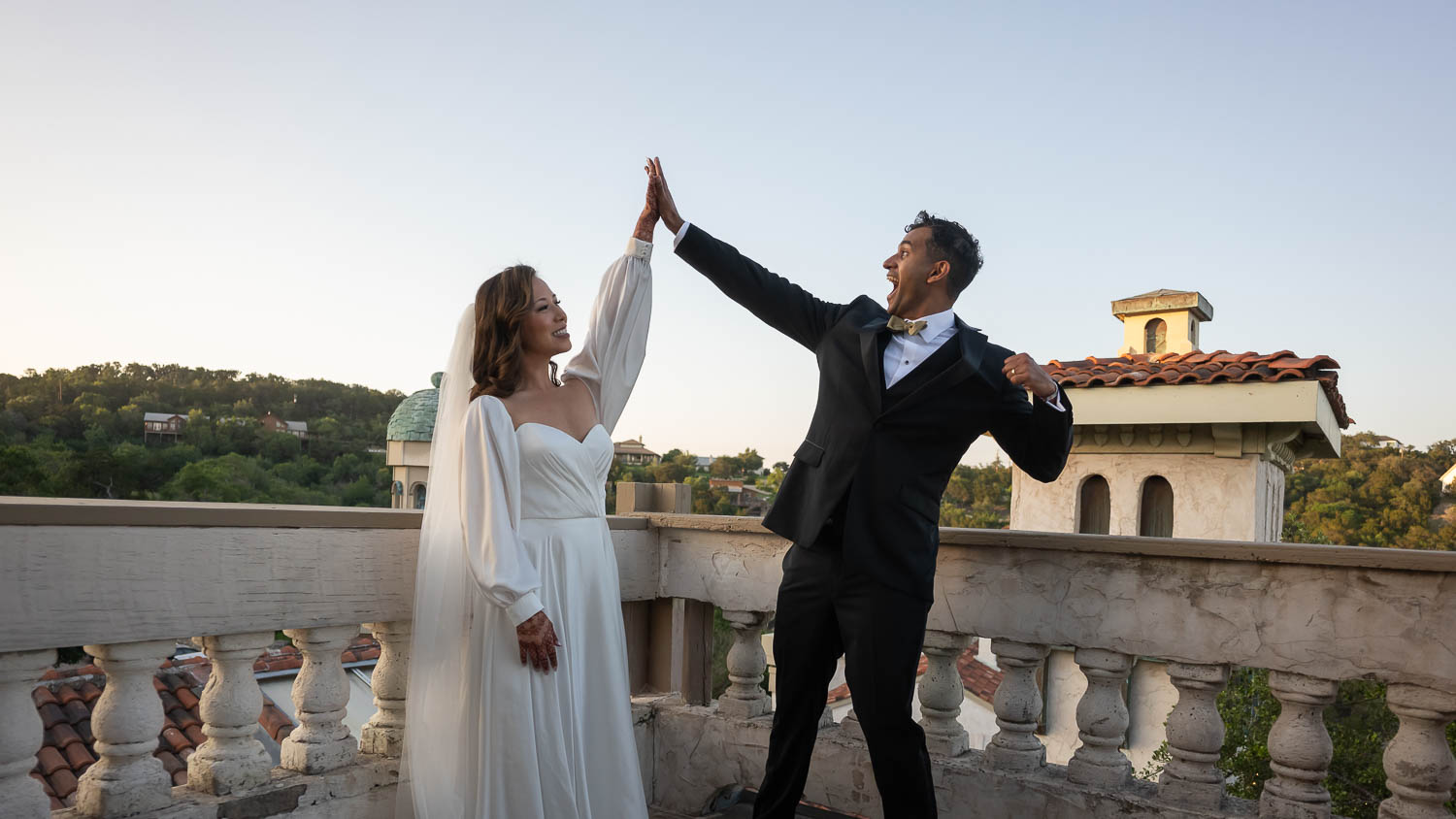 A Wedded couple high five at a South Asian Wedding at Villa Antonia L1100269