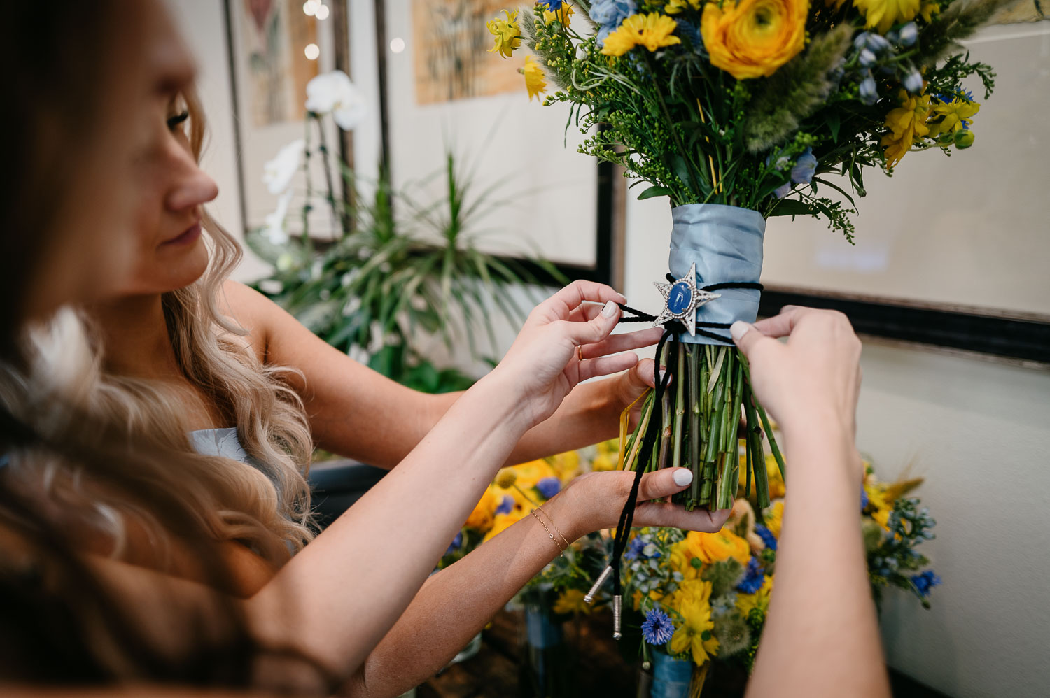 Wedding Ceremony St. Joseph's + The Westin Riverwalk, San Antonio 13 a woman tying a ribbon on a bouquet of flowers