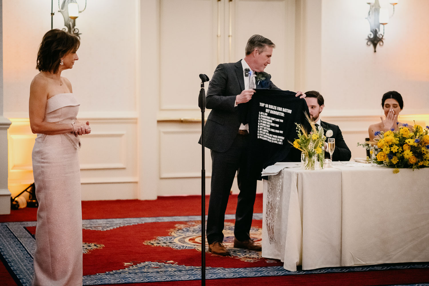Wedding Ceremony St. Joseph's + The Westin Riverwalk, San Antonio 53 a man holding a black shirt with a man in a white dress standing next to a table with a woman in a white dress