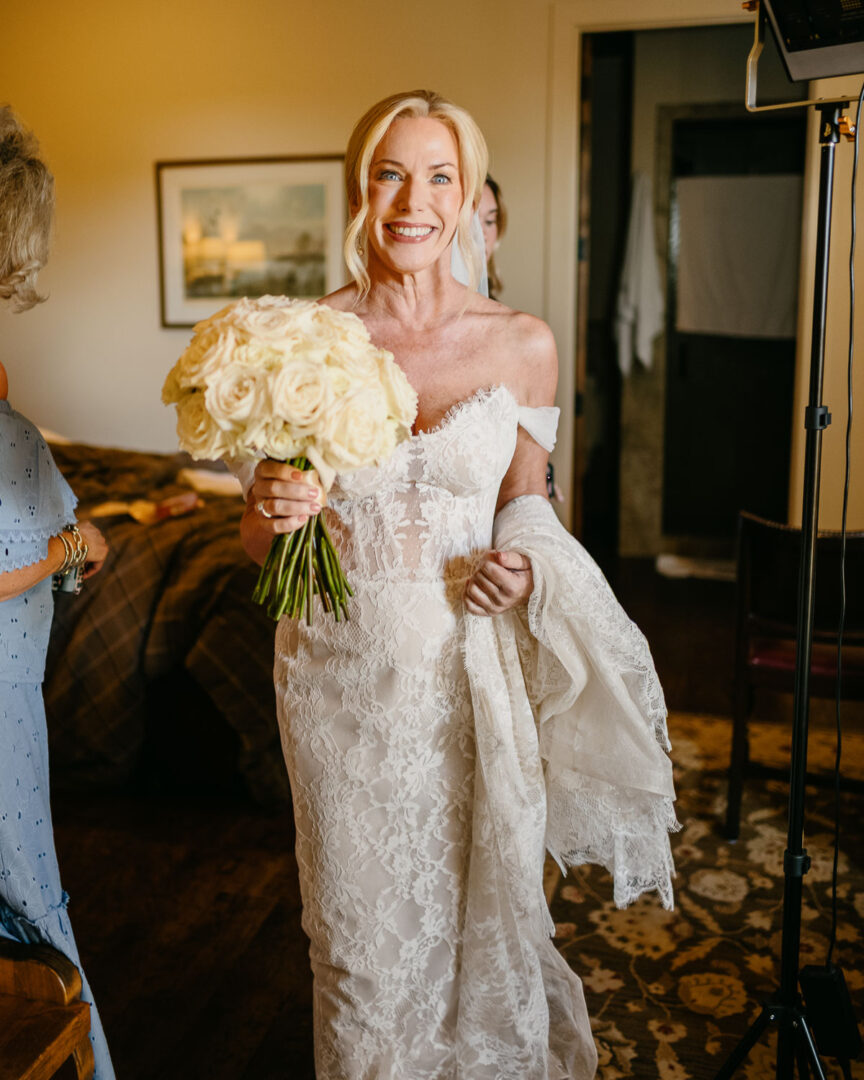 a woman in a white dress holding a bouquet of flowers