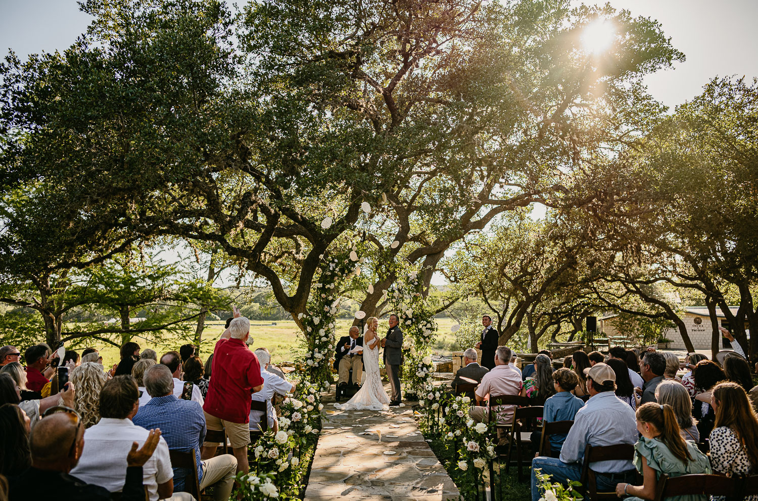 Texas Tech weddings, a tortilla-throwing tradition is incorporated to celebrate the couple, drawing inspiration from the university's football game tradition a man and woman under a tree on their wedding day
