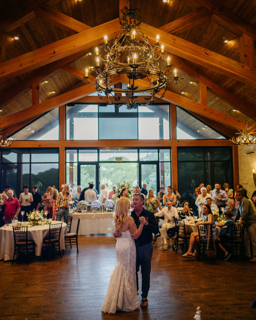 a man and woman dancing in a room with a group of people
