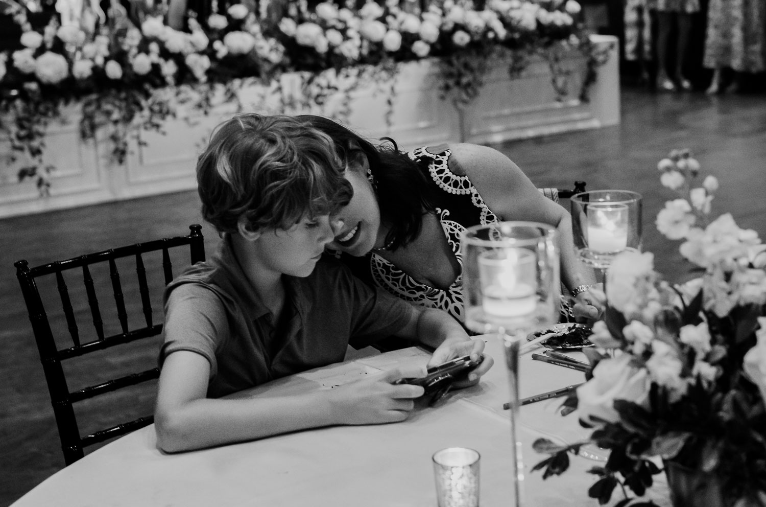 a woman and boy looking at a phone