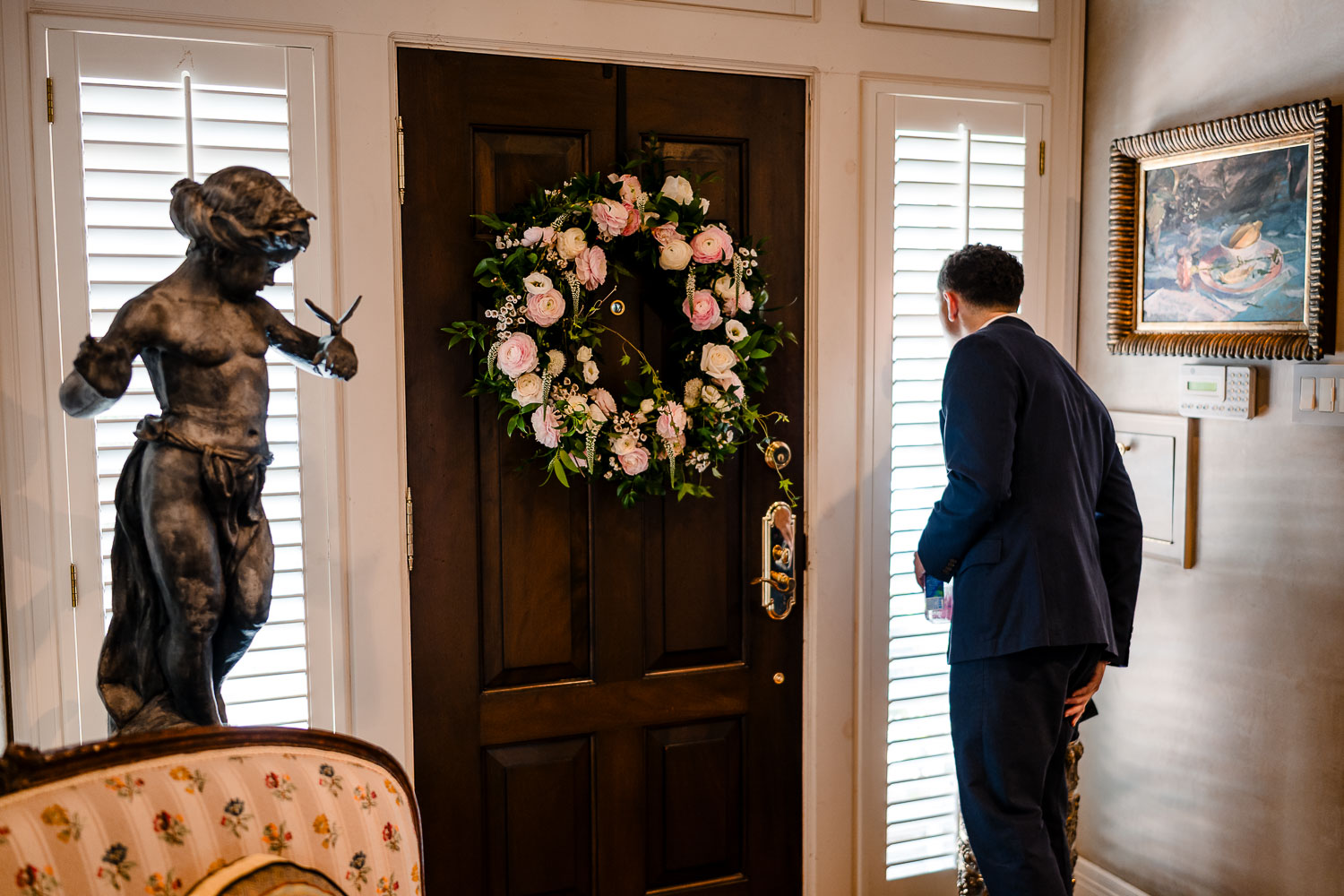 Elegant Houston Elopement | Caroline+George | Houston, Texas 8 Groom looking out door, floral wreath.