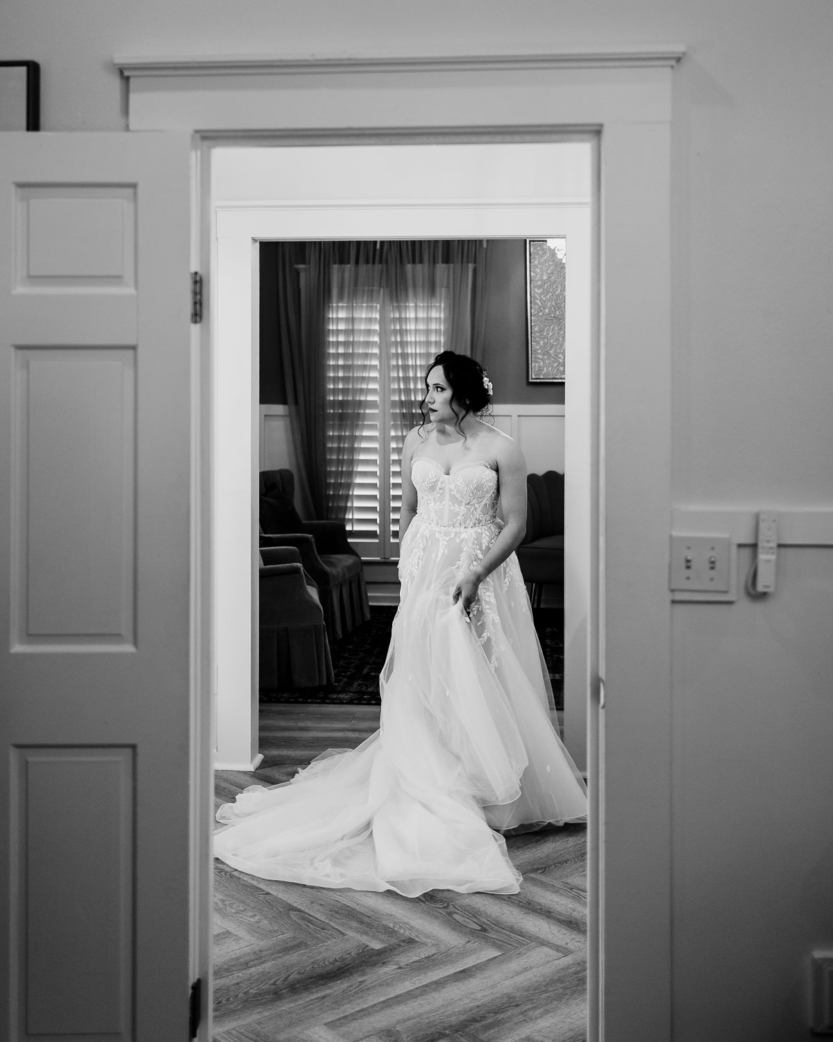 Bride in elegant wedding dress standing.