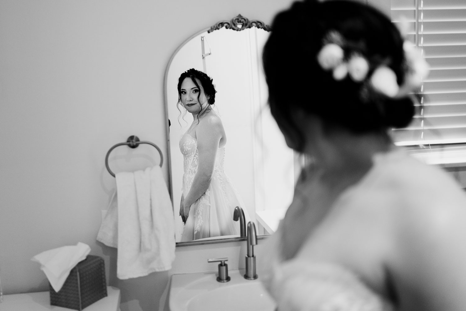 Bride preparing in elegant bathroom mirror.