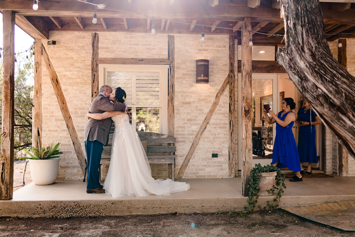 Couple embracing outside a rustic venue.