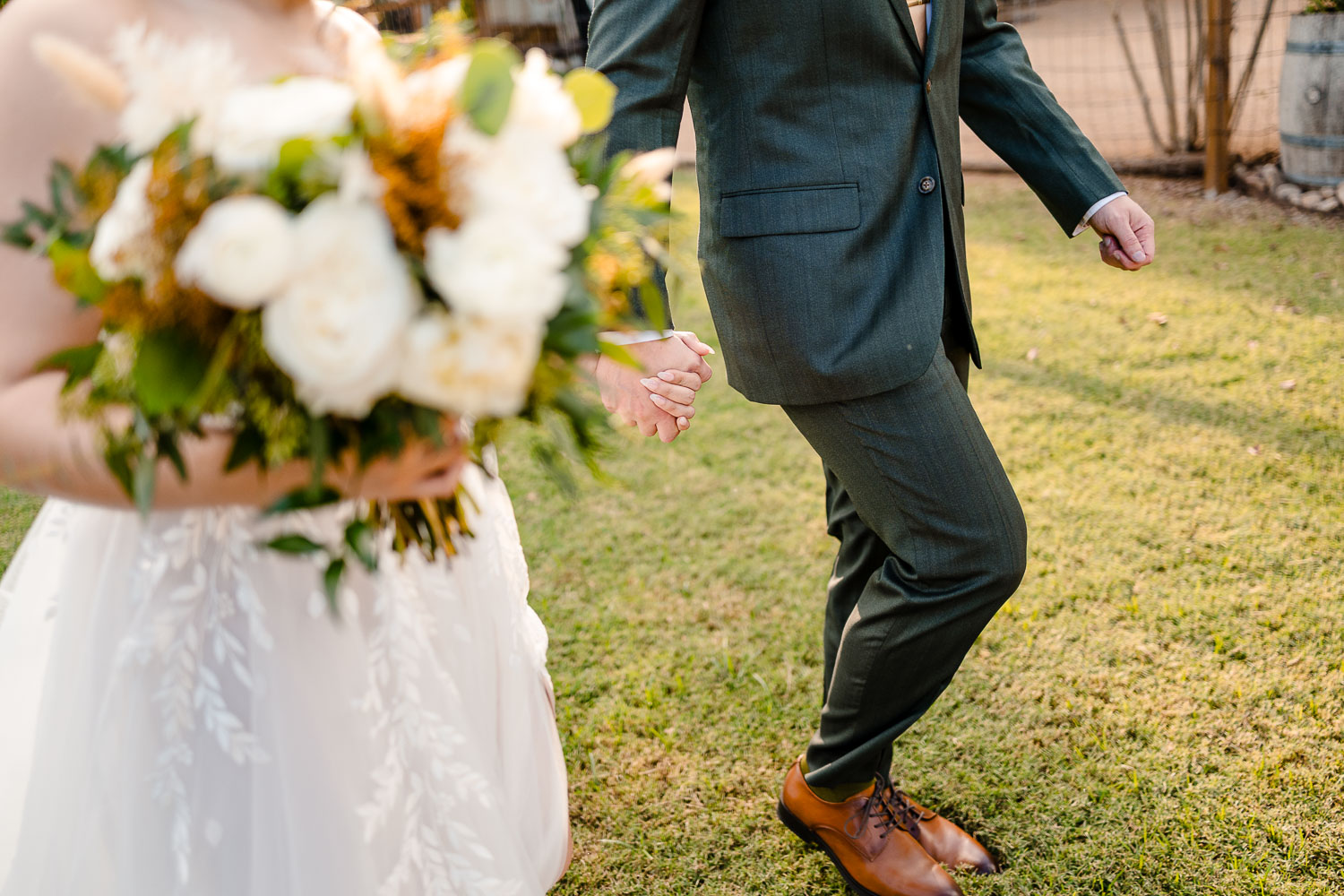 Couple holding hands, wedding attire.