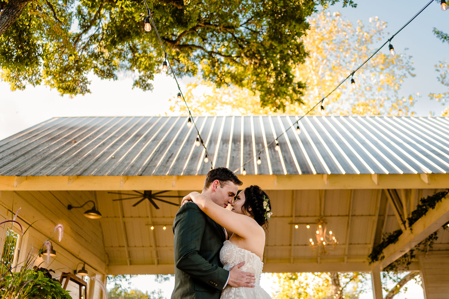 Couple embracing under string lights.