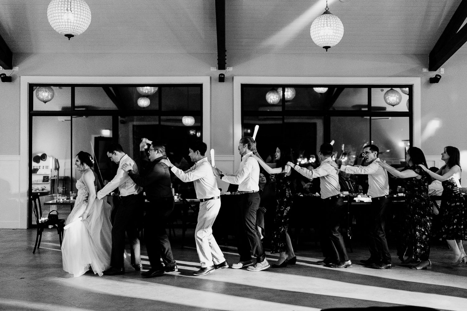 Wedding guests dancing in a line.