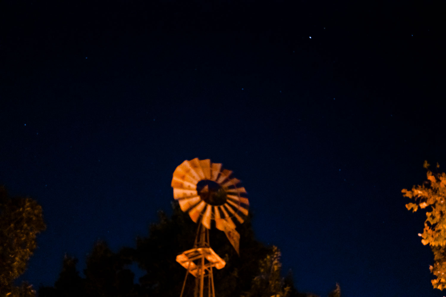 Windmill silhouette against starry night